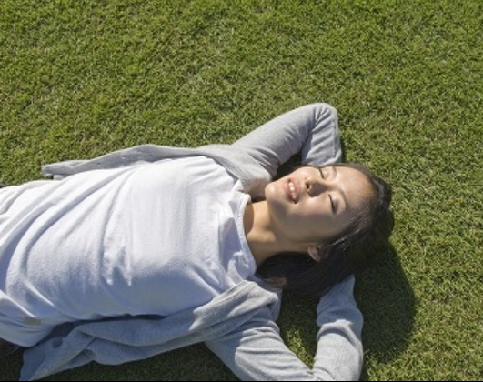 横たわる女性　芝生　日差しを浴びる.png